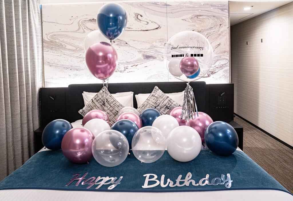 ホテルのベッドをネイビーとピンクのバルーンで彩る2周年記念・誕生日サプライズ飾り付け