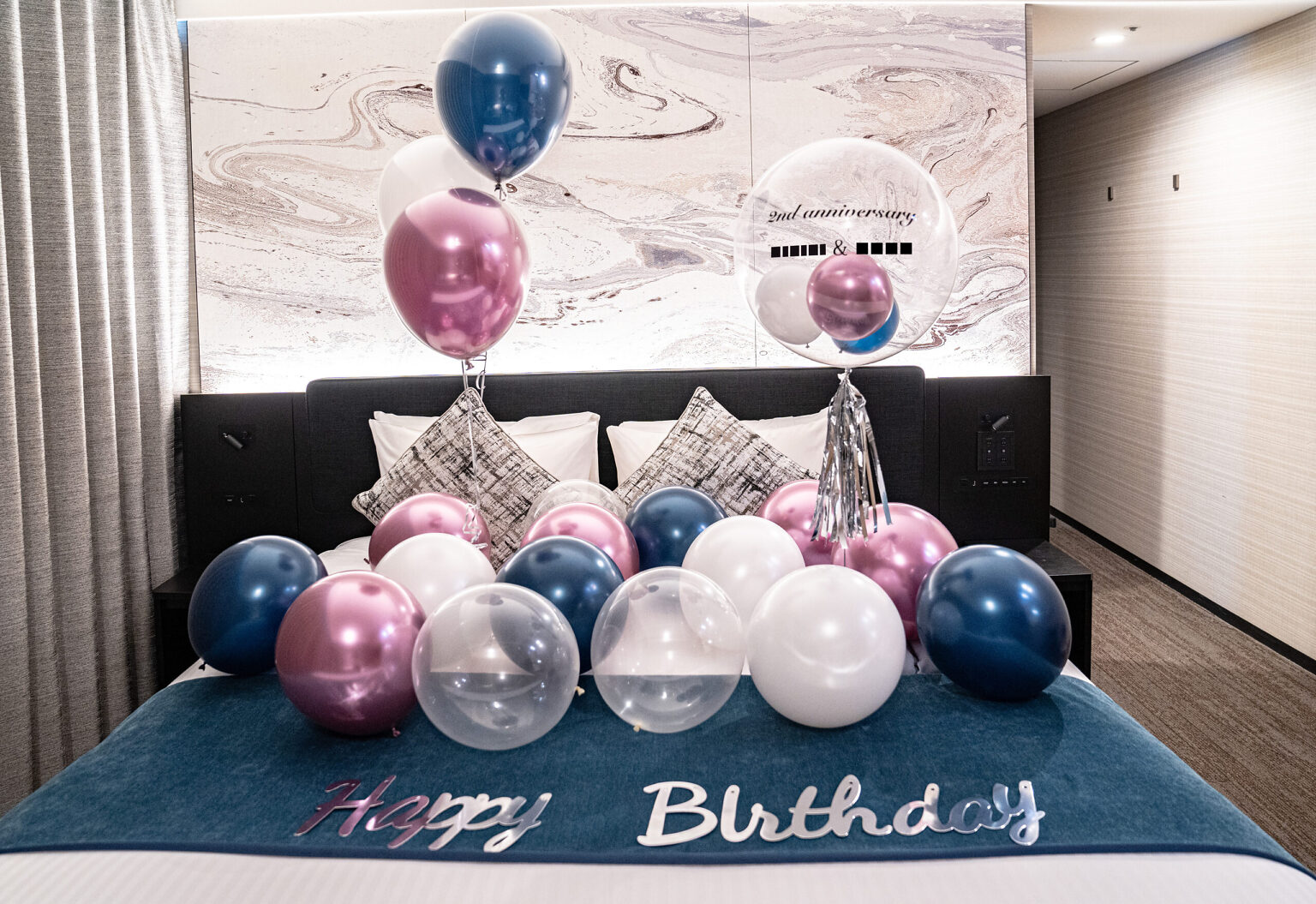 ホテルのベッドをネイビーとピンクのバルーンで彩る2周年記念・誕生日サプライズ飾り付け