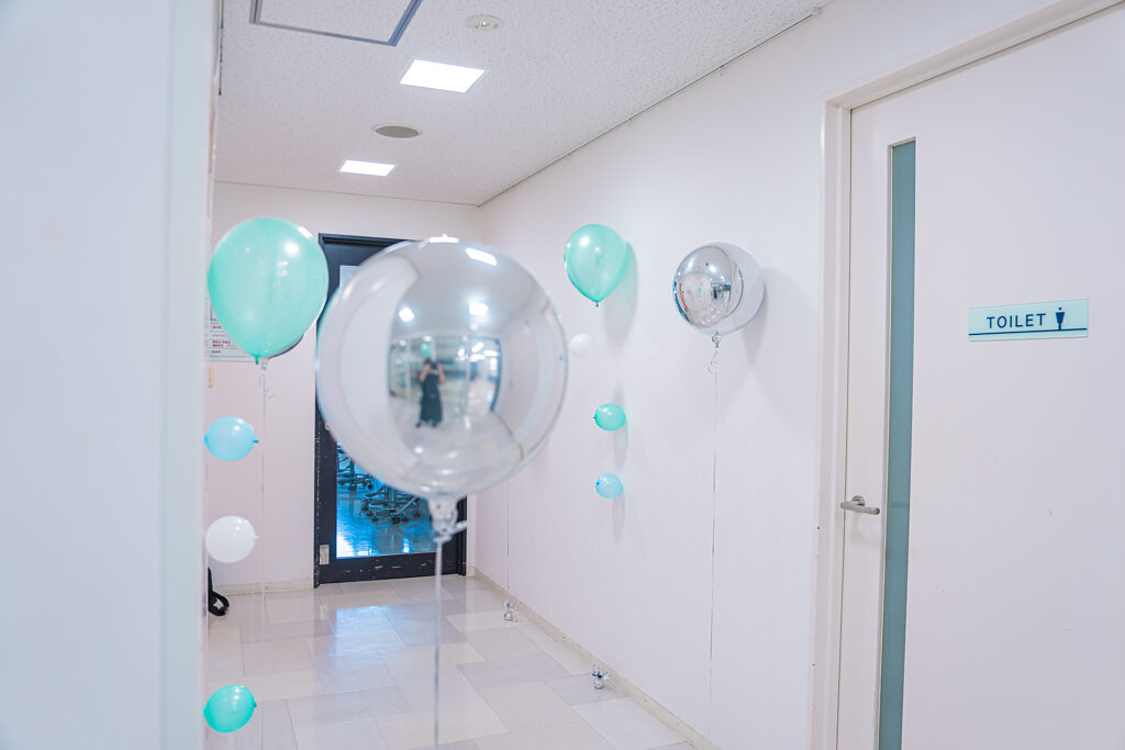 ミントグリーンと白で彩るエントランスのお祝いバルーン飾り付け