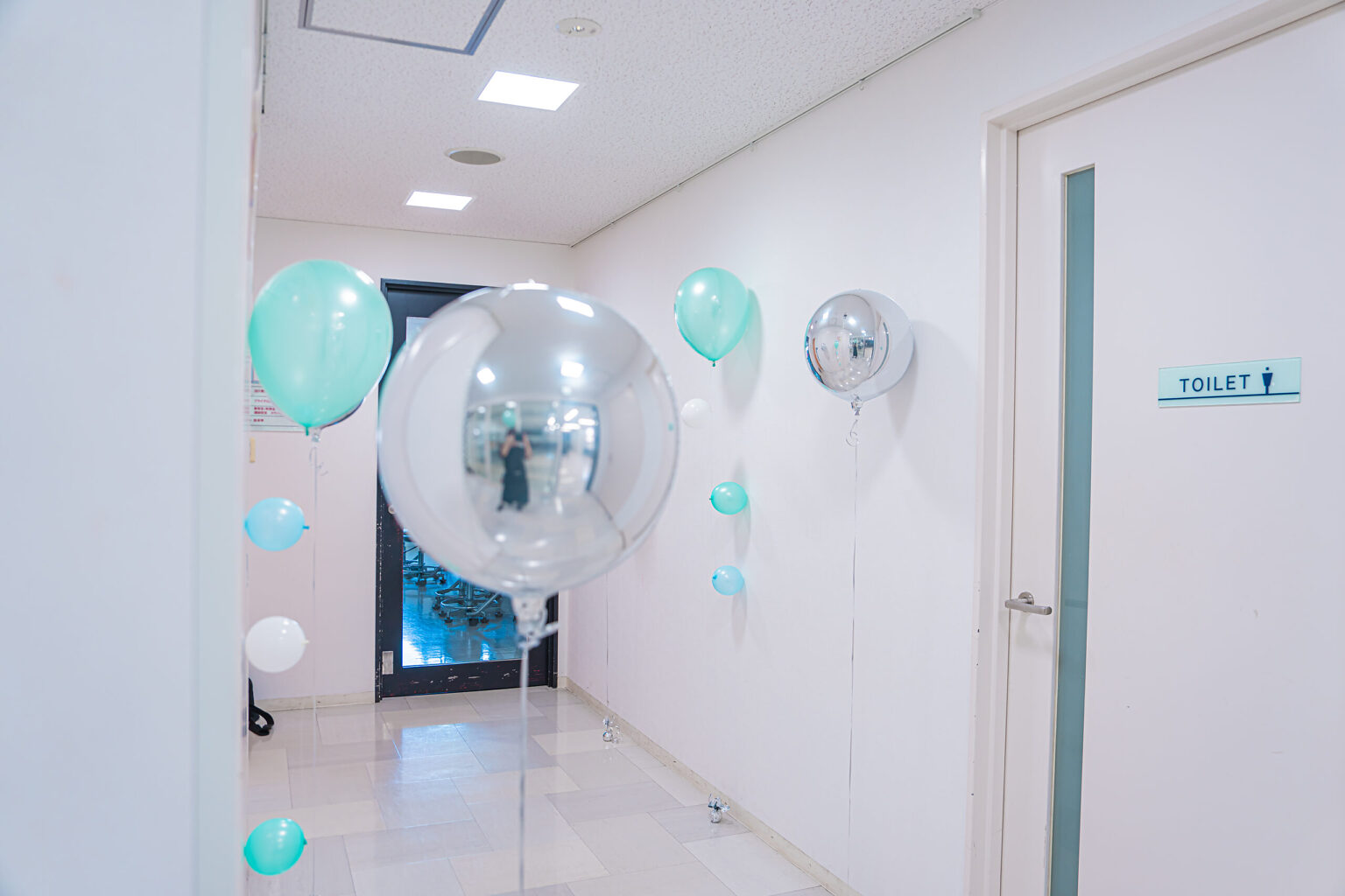ミントグリーンと白で彩るエントランスのお祝いバルーン飾り付け