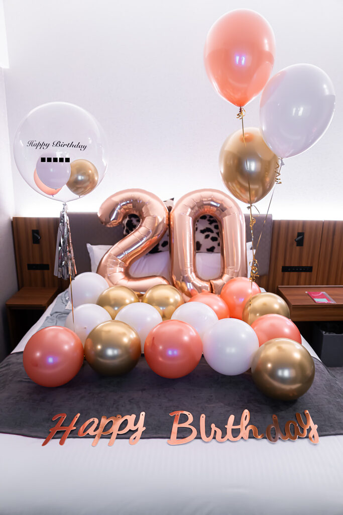 ホテルの客室でローズゴールドのバルーンを飾る誕生日サプライズ飾り付け