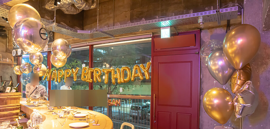 レストランの窓際をゴールドで彩る誕生日お祝いバルーン飾り付け