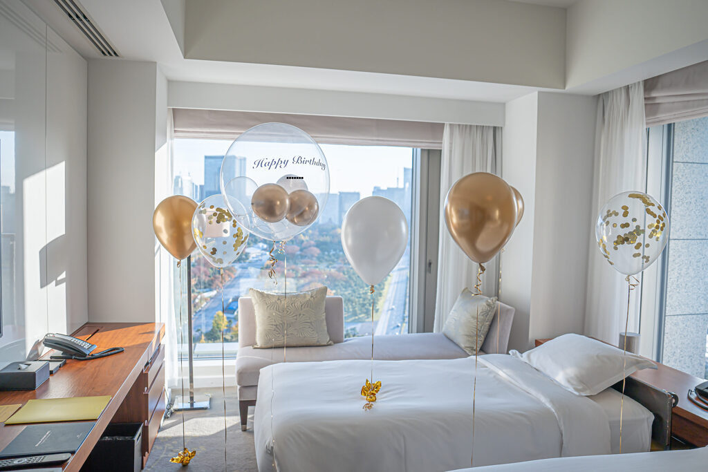 ゴールドとホワイトのバルーンで彩るホテル客室の誕生日サプライズ飾り付け