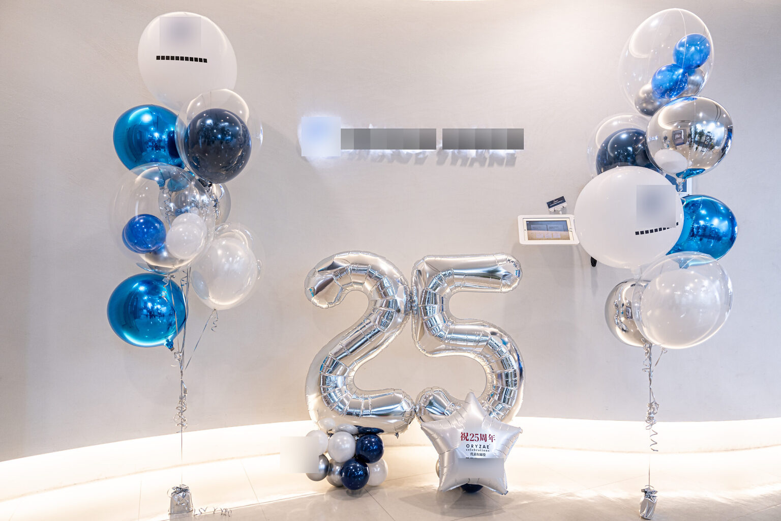 東京のエントランスを彩るブルーとシルバーの25周年お祝い飾り付け