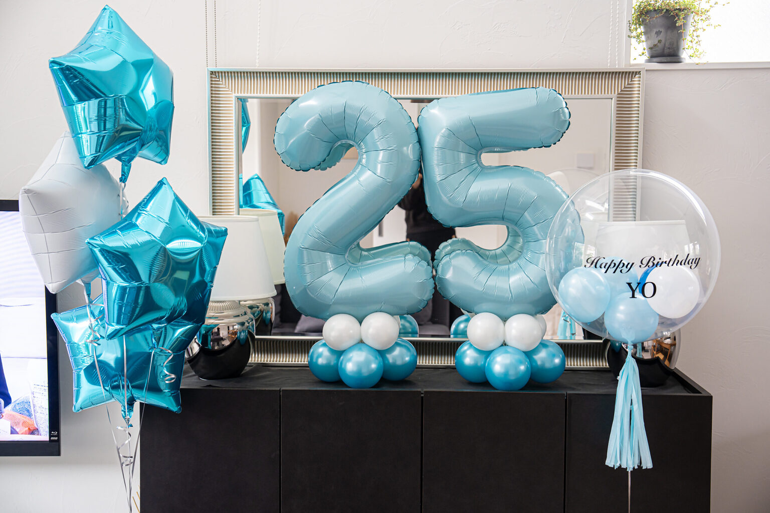 在东京家中用浅蓝色和白色气球进行的25岁生日惊喜布置