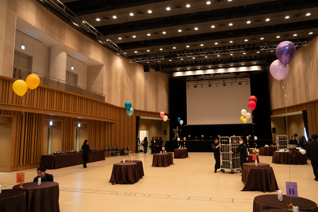 品川インターシティホール＆貸会議室のステージを彩るグリーンとゴールドのお祝いバルーン装飾