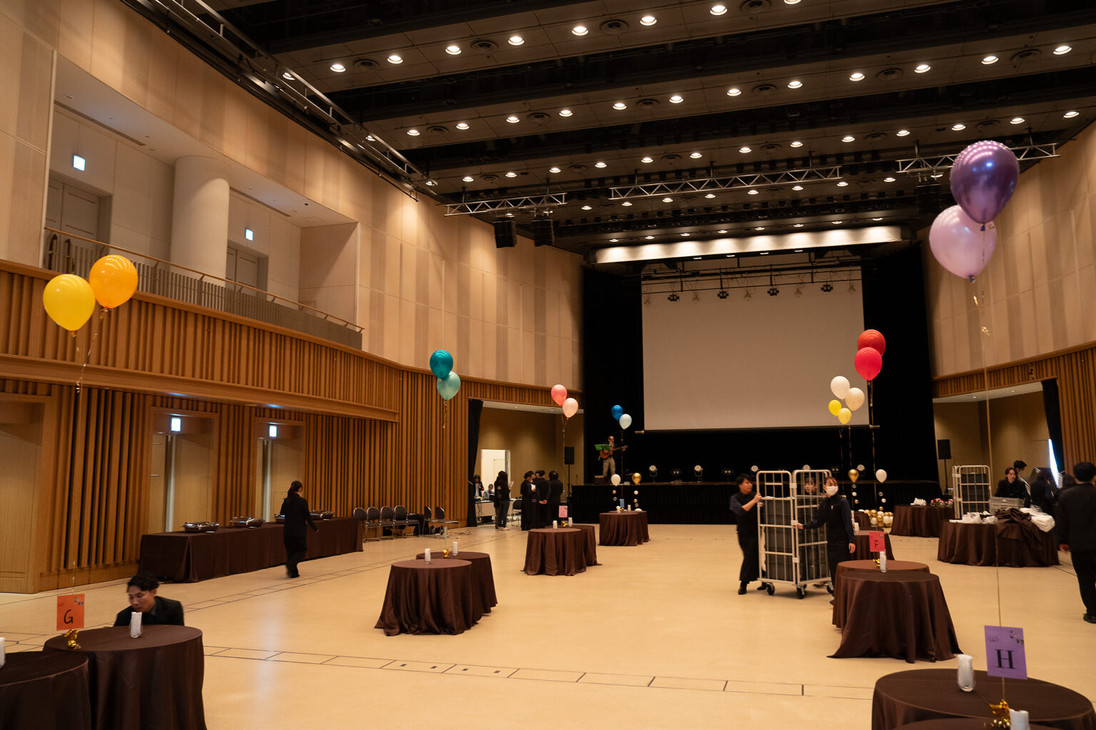 品川インターシティホール＆貸会議室のステージを彩るグリーンとゴールドのお祝いバルーン装飾