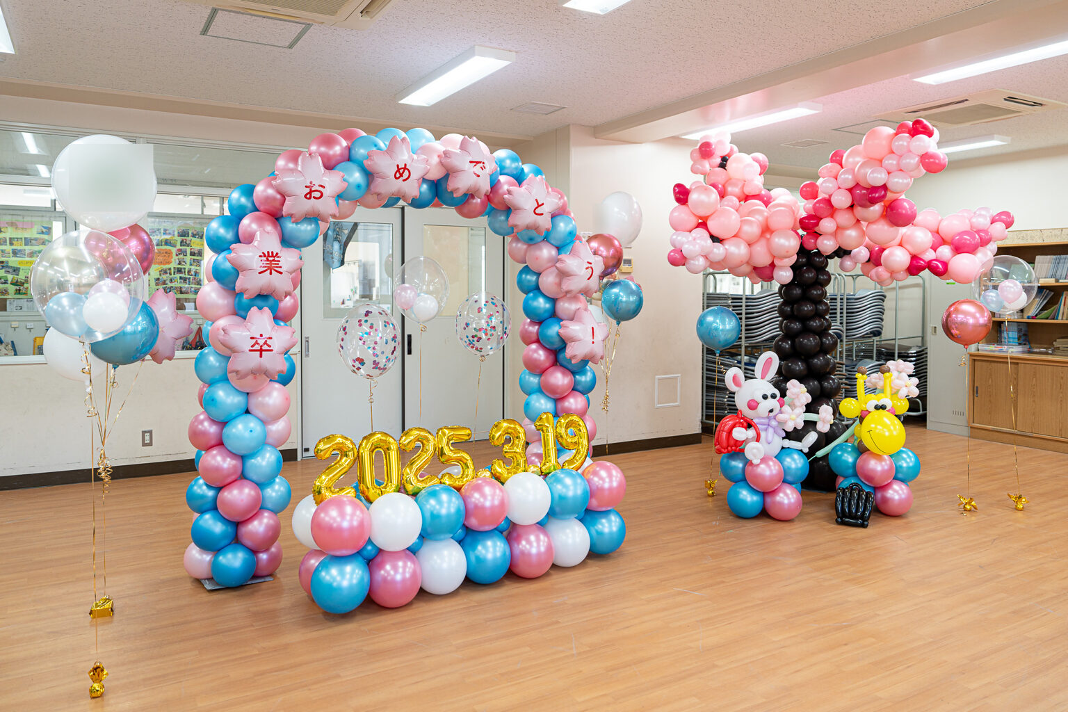 ピンク・水色・白・金のバルーンアーチで彩る卒業お祝い装飾