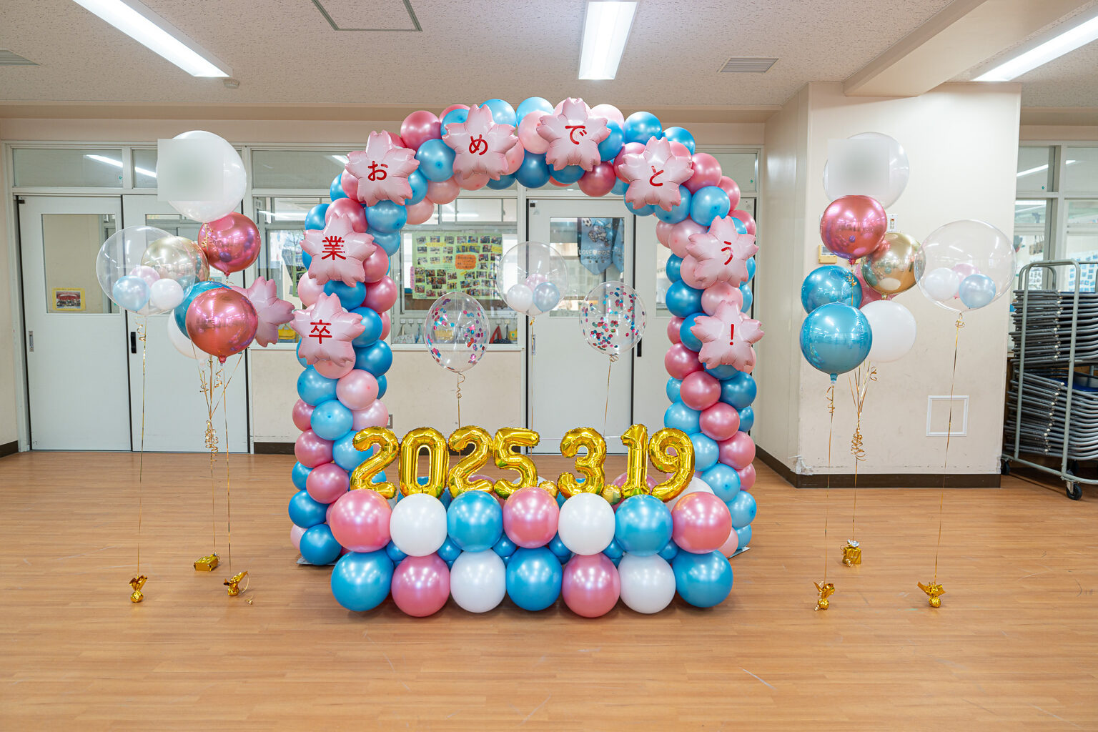 ピンク・水色・白・金のバルーンアーチで彩る卒業お祝い装飾