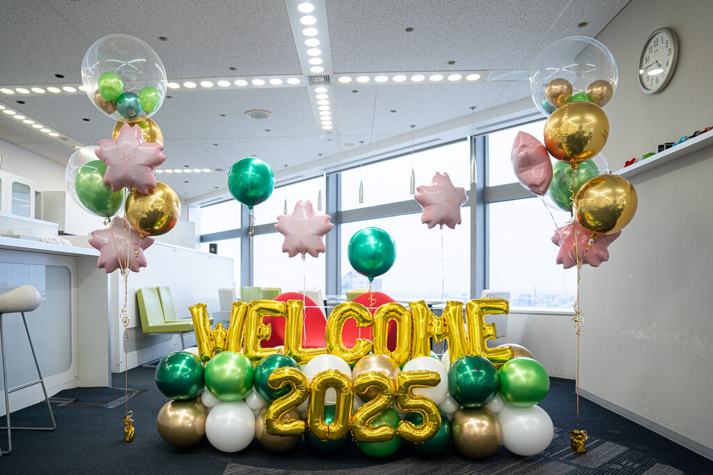 西新宿のオフィスでの入社式を彩るグリーンとゴールドのバルーン飾り付け
