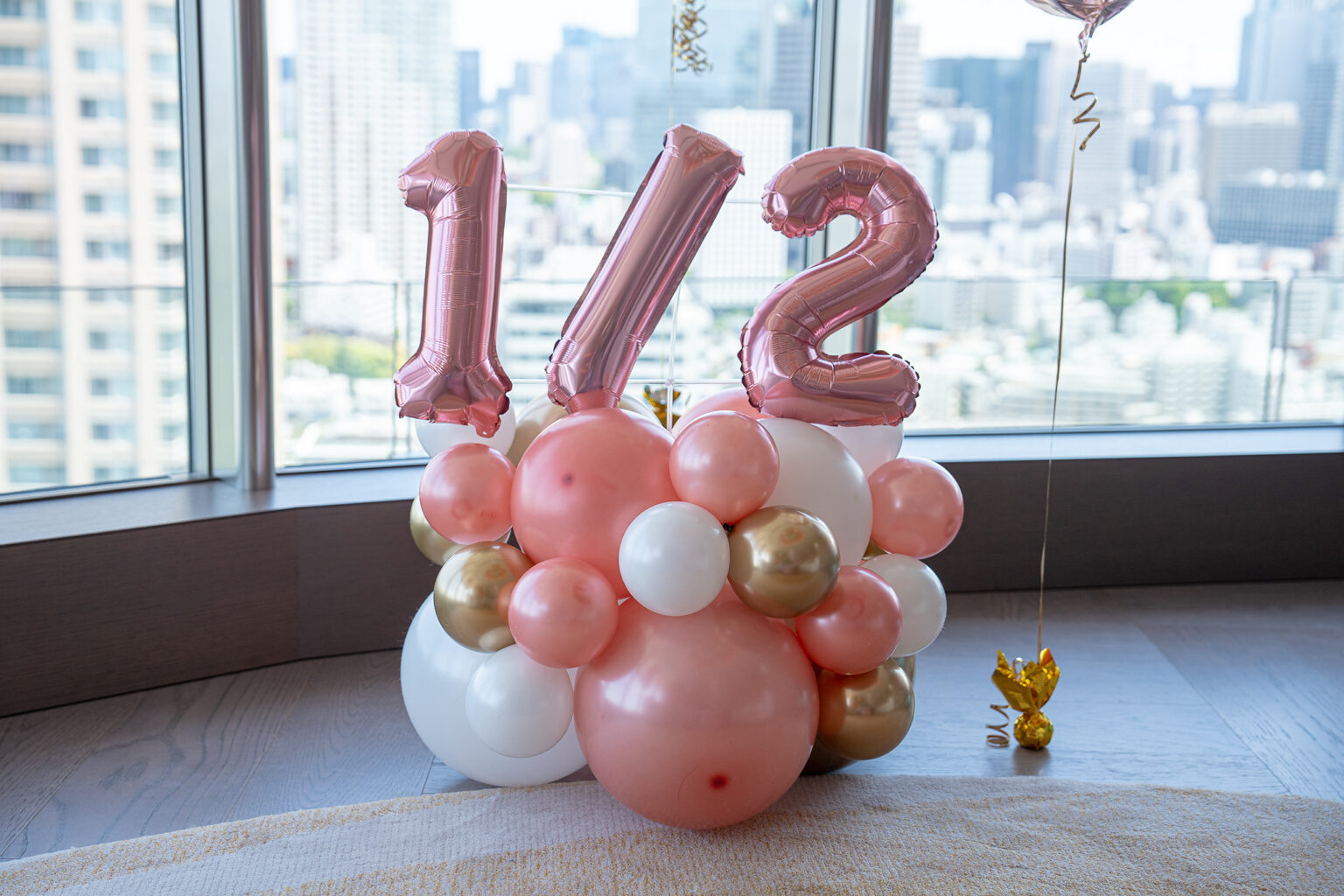 東京の自宅でのローズゴールドと白の天井バルーン誕生日飾り付け