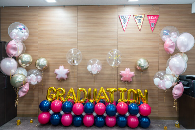 Celebrating the graduation ceremony of Meguro Nihon University High School with gold, dark navy, and pink balloon decorations