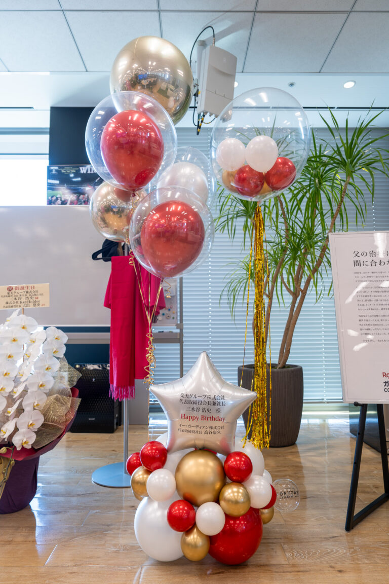 Birthday balloon decoration at 楽天クリムゾンハウス, a luxurious tower celebration display in red, gold, and white