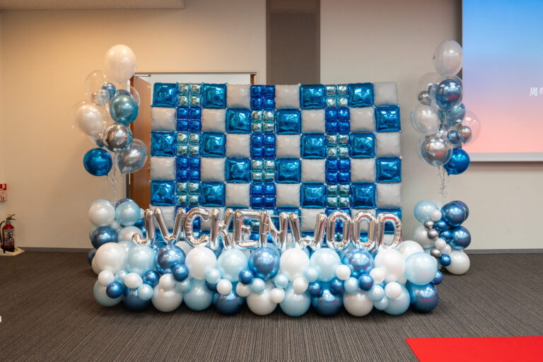 Anniversary celebration party decorations featuring large blue and white balloon displays