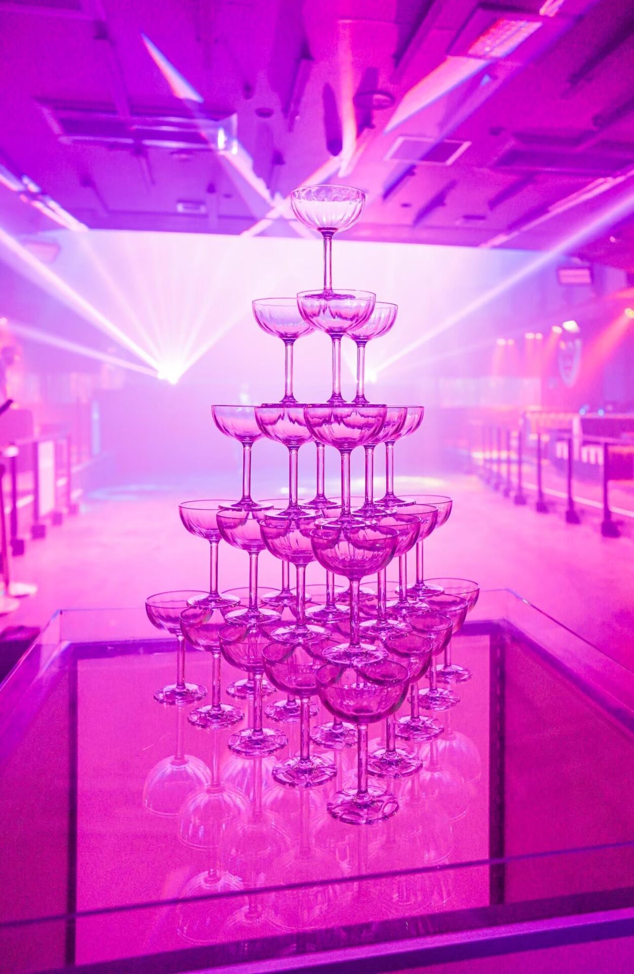 Champagne tower shining in the light at a live concert venue