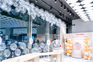 天井から吊るしたクリアバブルバルーンのガーランドとオレンジ・ホワイトのバルーンタワーによるコスメブランド店頭装飾